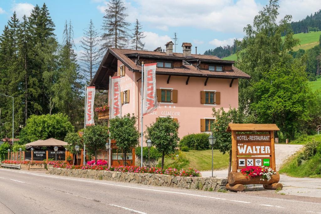 a building with a sign on the side of a road at Hotel Walter in San Candido