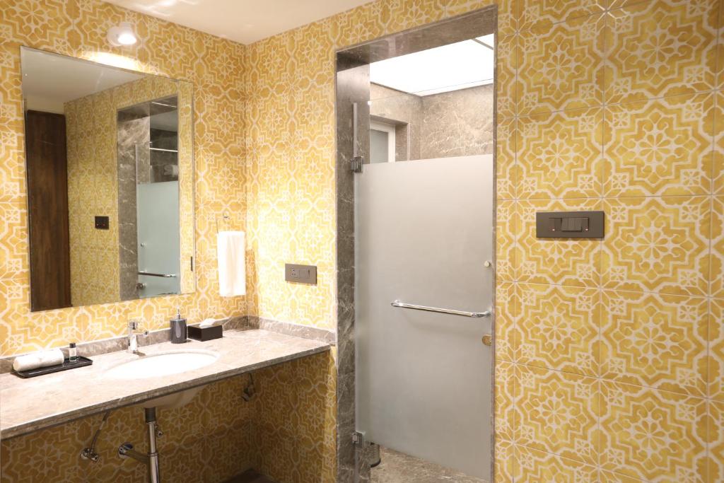 a bathroom with a sink and a mirror and a shower at Golden Fields Resort in Mulshi