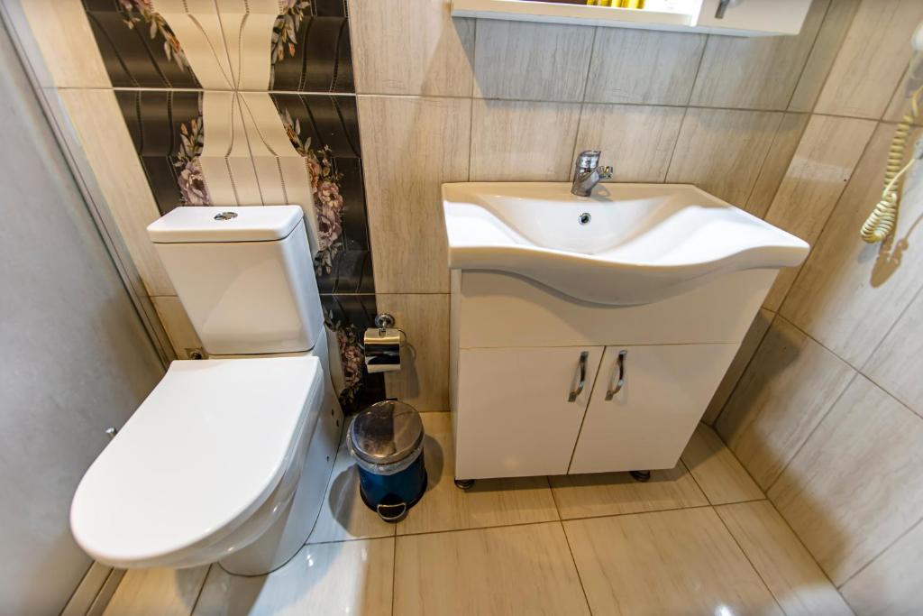La salle de bains est pourvue de toilettes blanches et d'un lavabo. dans l'établissement Gul Otel, à Istanbul