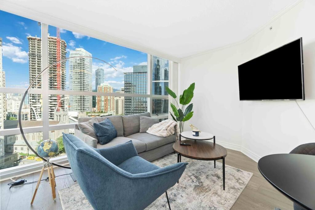 uma sala de estar com um sofá e uma grande janela em 2BR Condo with breathtaking view in Downtown! Free parking - 6 sleep em Vancouver