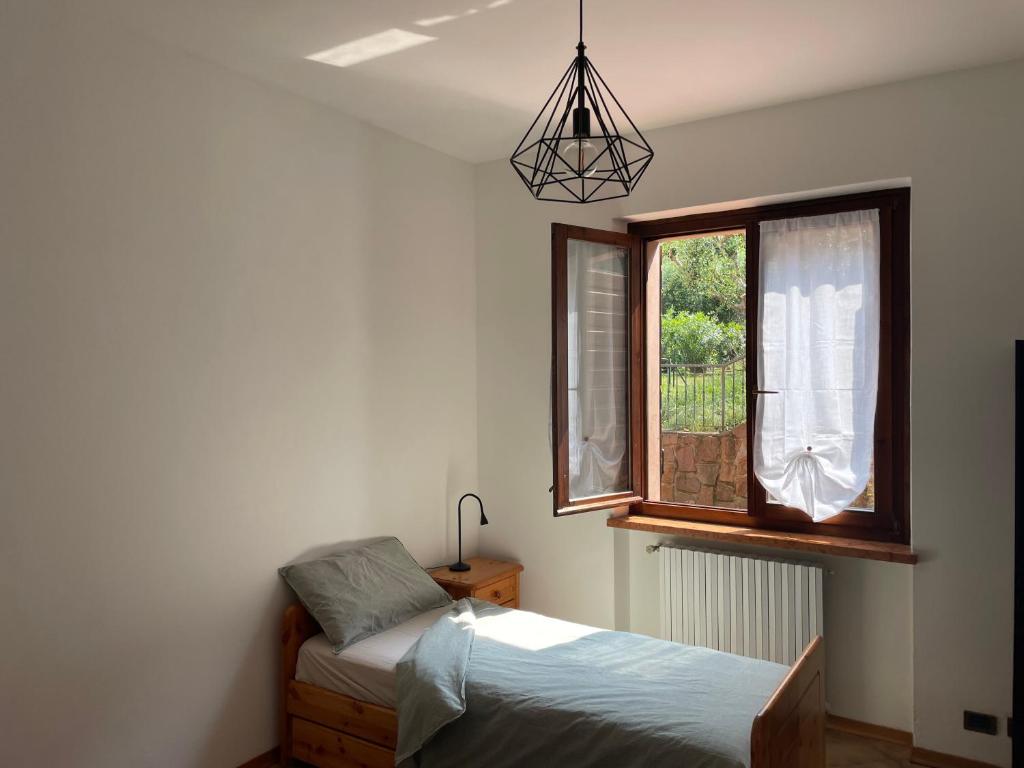 Schlafzimmer mit einem Bett und einem Fenster in der Unterkunft [The window On The Valdadige] Sport and Nature 