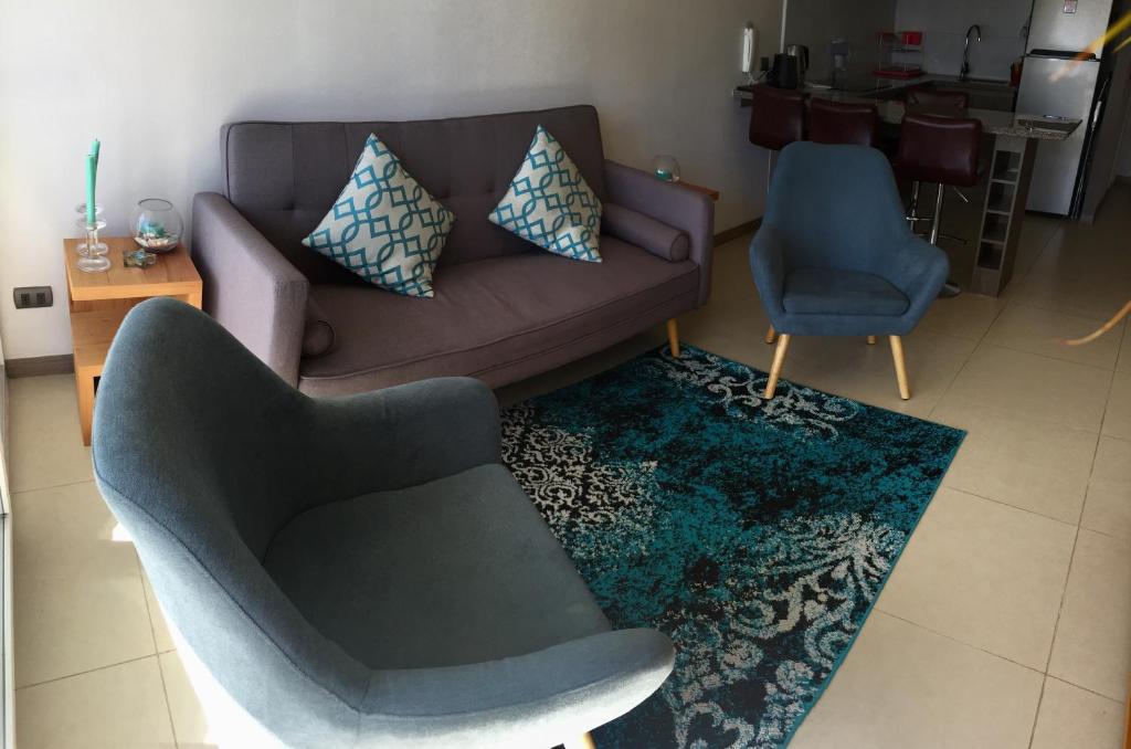 a living room with a couch and two chairs at Acogedor departamento a pasos de la playa in Coquimbo