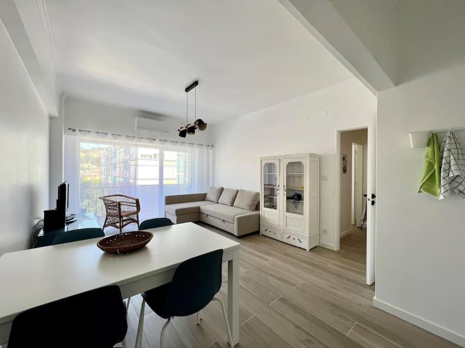 a white living room with a table and chairs at Apartamento muito central - 300 metros da Praia in Costa da Caparica