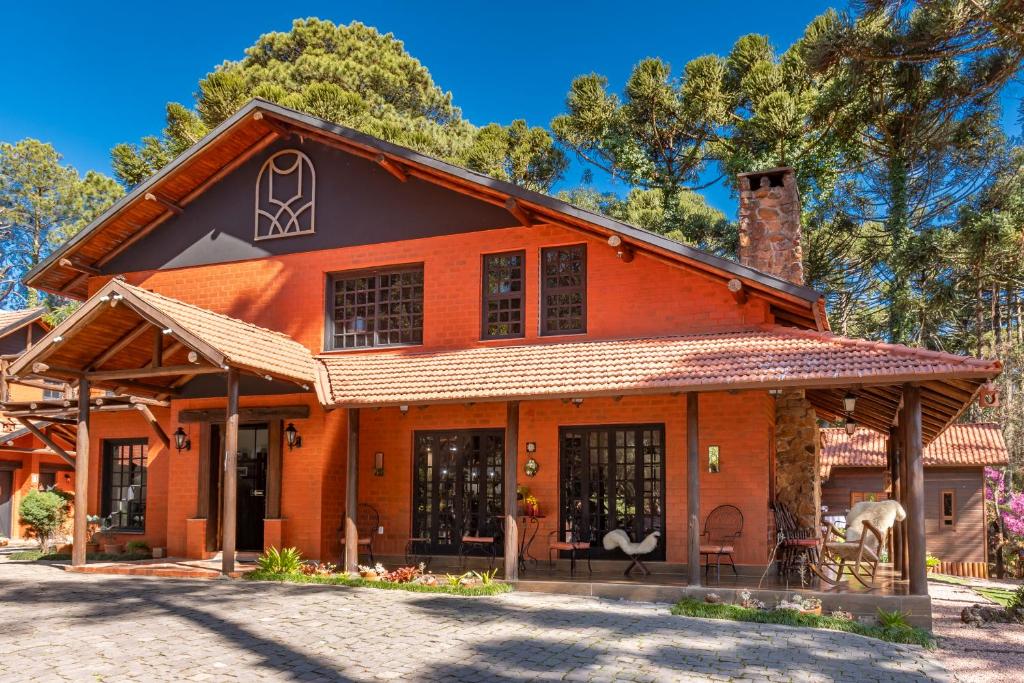 ein orangefarbenes Haus mit einem Gamer-Dach in der Unterkunft Pousada Vila 505 in Canela