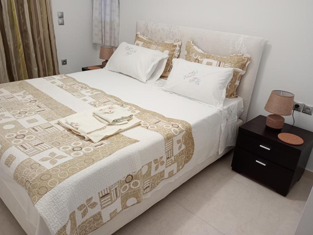 a bedroom with a large bed and a night stand at Coastal Garden Getaway in Metókhi
