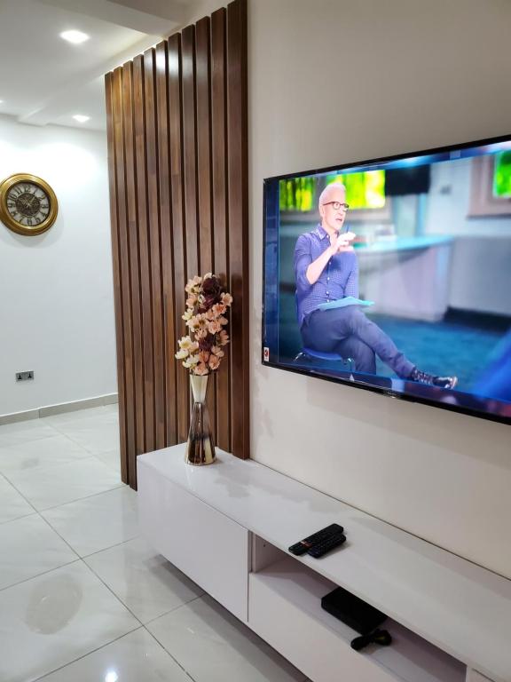 TV de pantalla plana en una pared blanca en Home away from home #1 en Accra