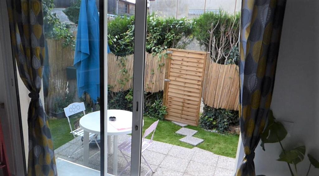 a view of a garden through a sliding glass door at studio cosy indépendant avec baie vitrée et jolie terrasse in Coulommiers