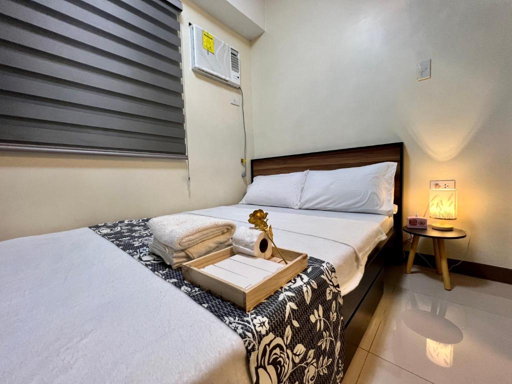 a bedroom with two beds and a window with a sink at Condotel Room to Stay Lodging in Manila