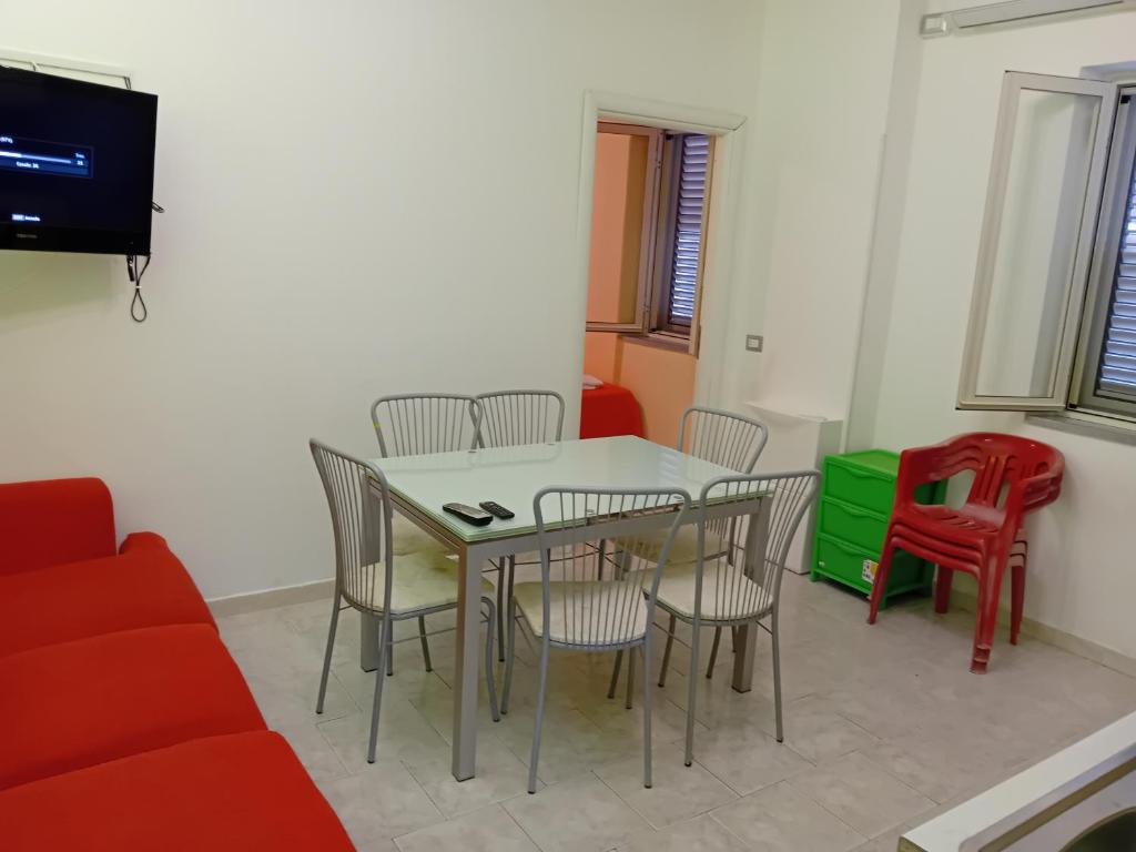 een woonkamer met een tafel en stoelen en een televisie bij Casa relax in Vibo Valentia Marina