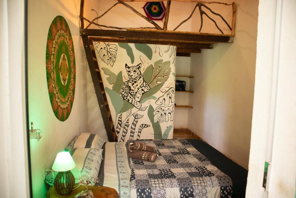 a small room with a bed and a table with a lamp at Espaço Cultural Lotus - Suítes, Hostel e Camping in Alto Paraíso de Goiás