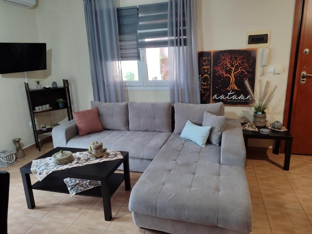 sala de estar con sofá y mesa en Όμορφο διαμέρισμα σε μονοκατοικία στη Λεπτοκαρυα., en Leptokarya