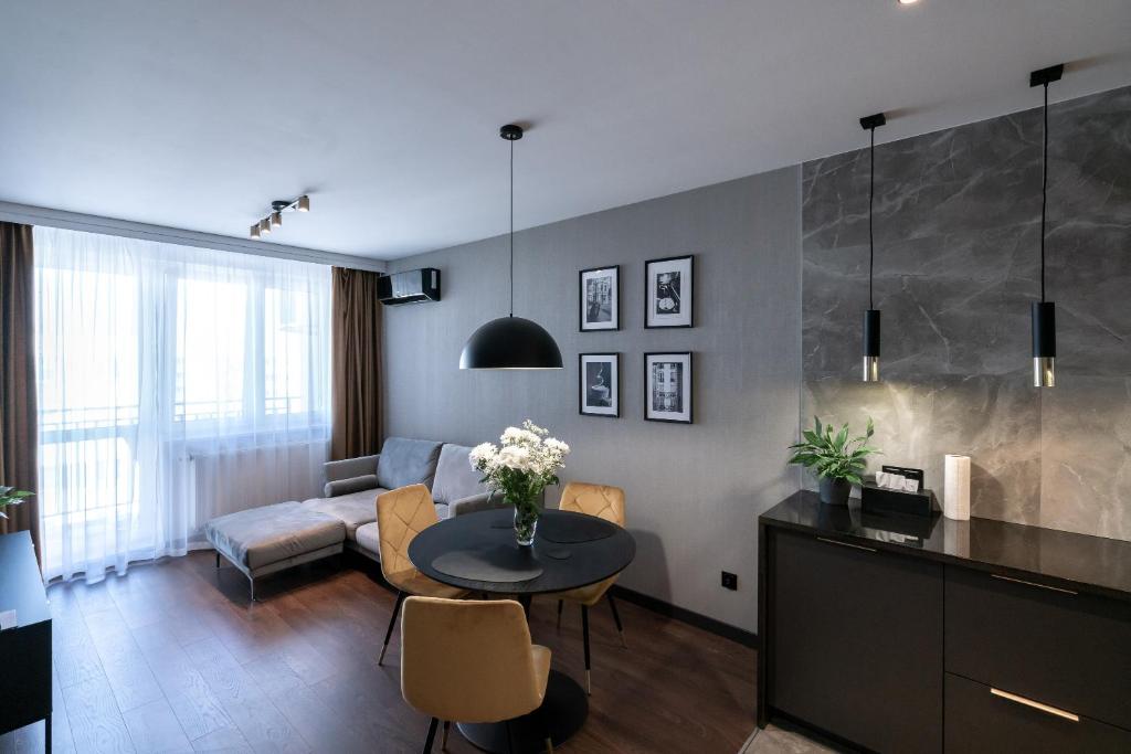 a living room with a table and a couch at Noche Apartamenty Premium in Biała Podlaska