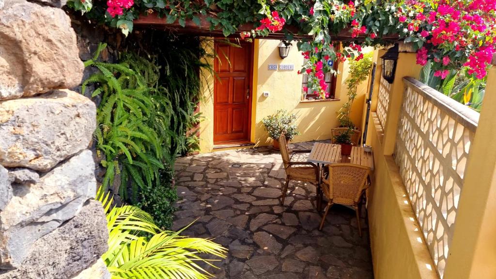 an alley with flowers and a door and a table at Los Nacientes: Cordero in Los Sauces