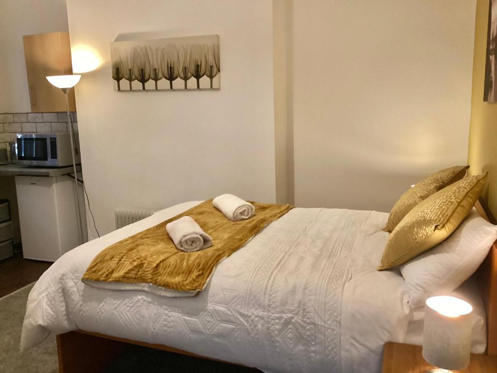 a bedroom with a bed with two towels on it at Coventry Train station studio in Coventry