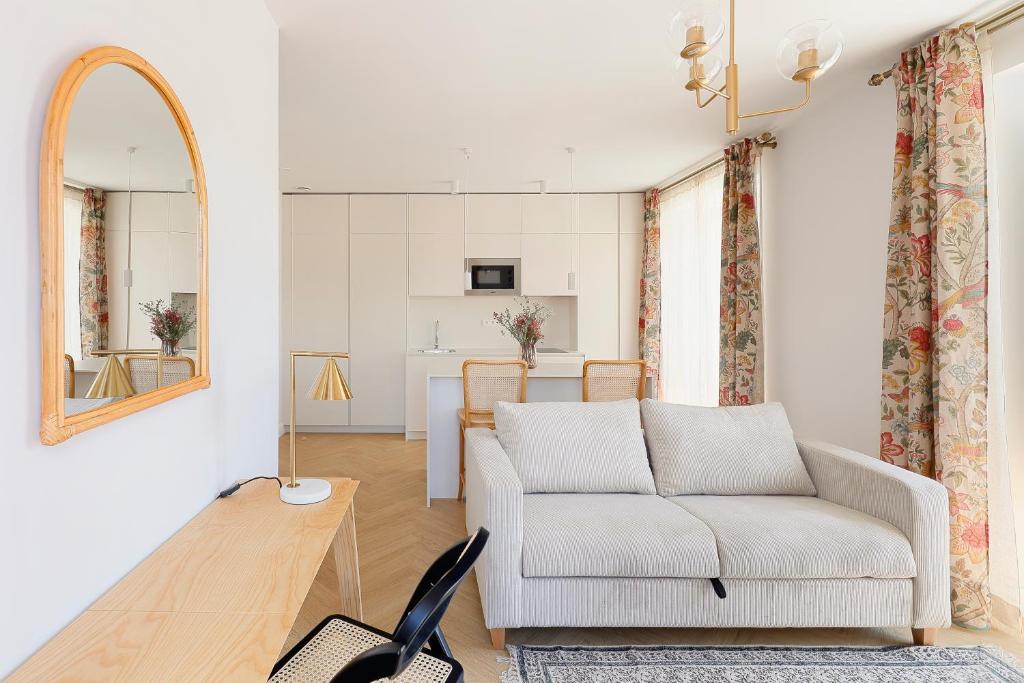 ein Wohnzimmer mit einer Couch und einem Spiegel in der Unterkunft Apartamentos La Colonia de Muros in Muros de Nalón