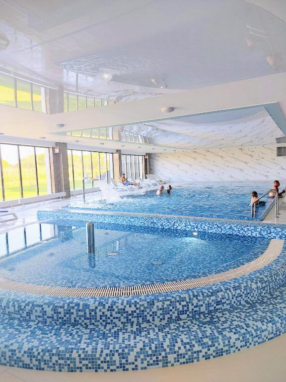 a large swimming pool with people in the water at Porta Mare Marine in Dziwnów