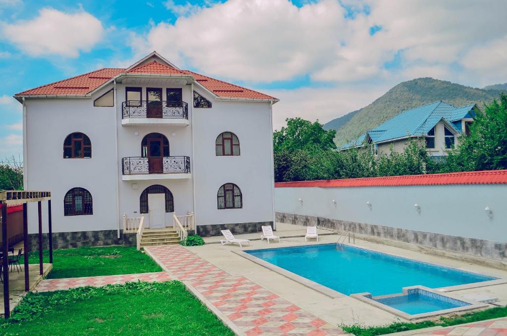 a villa with a swimming pool in front of a house at Gabala Regnum Family Villa in Gabala