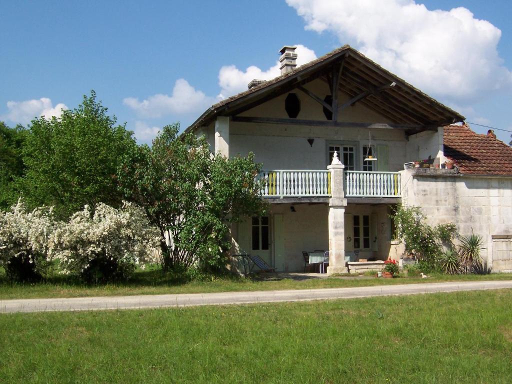 a white house with a balcony on top of it at Mistoury in La Tour-Blanche