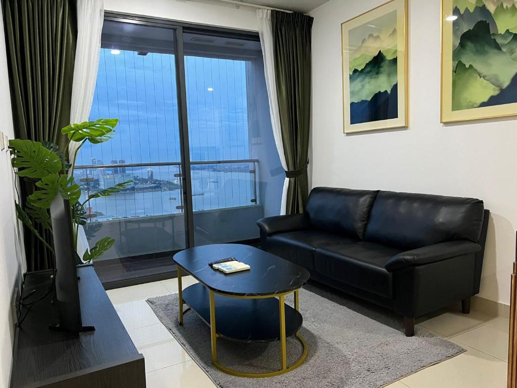 a living room with a black leather couch and a table at ImPian 2Br Condo in Phnom Penh