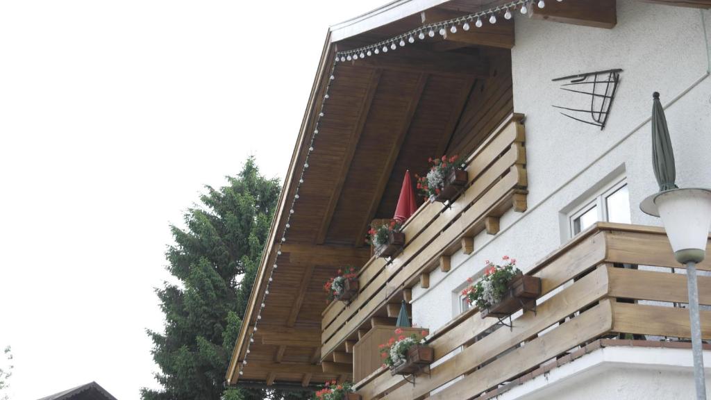 uma casa com escadas de madeira e vasos de plantas em Alpenblümchen Apts. der Kornauer Stuben em Oberstdorf