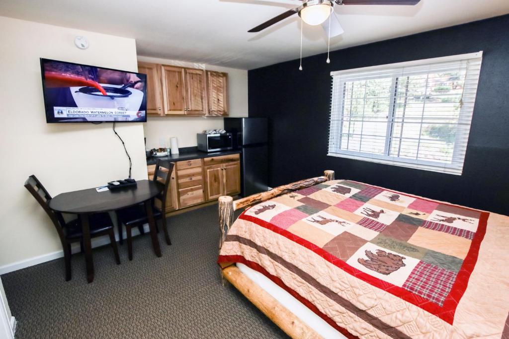 a bedroom with a bed and a table and a kitchen at Fawn Valley Inn- 294 condo in Estes Park
