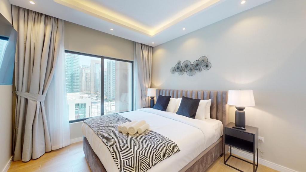 a bedroom with a large bed and a large window at Time Place Tower - Vacationer in Dubai