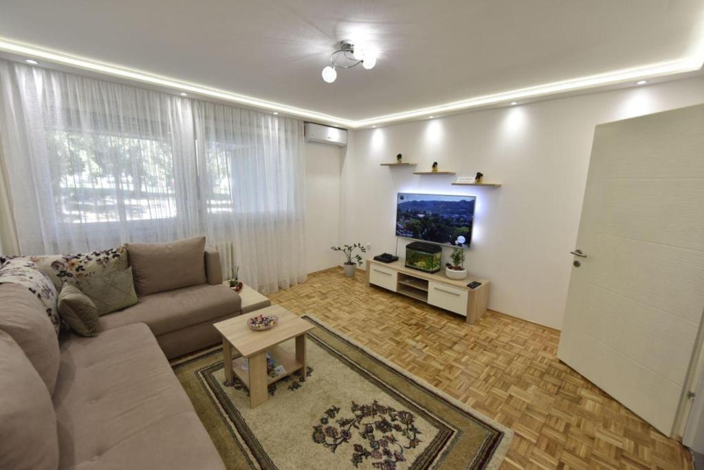 sala de estar con sofá y TV de pantalla plana en Apartman Isidora en Banja Luka