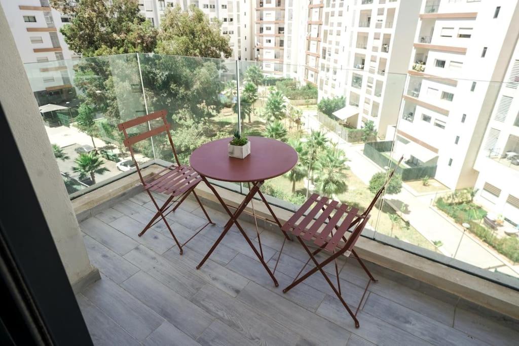 une table et deux chaises assises sur un balcon dans l'établissement Luxury Prestigia 2Bed Rooms, à Rabat