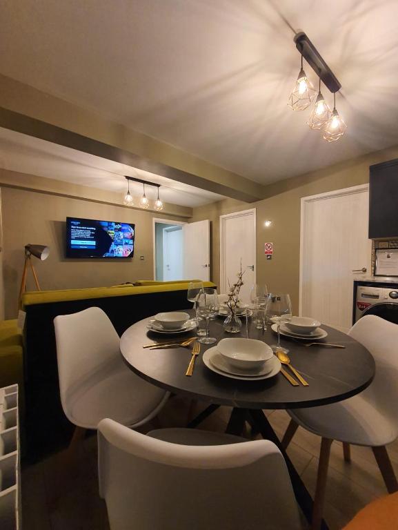 a dining room with a table and chairs and a television at Stylish Kent Gem - Free WiFi in Kent
