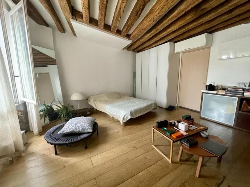 Sala de estar con cama y mesa en Big Luxury Studio in the heart of St-Germain, en París