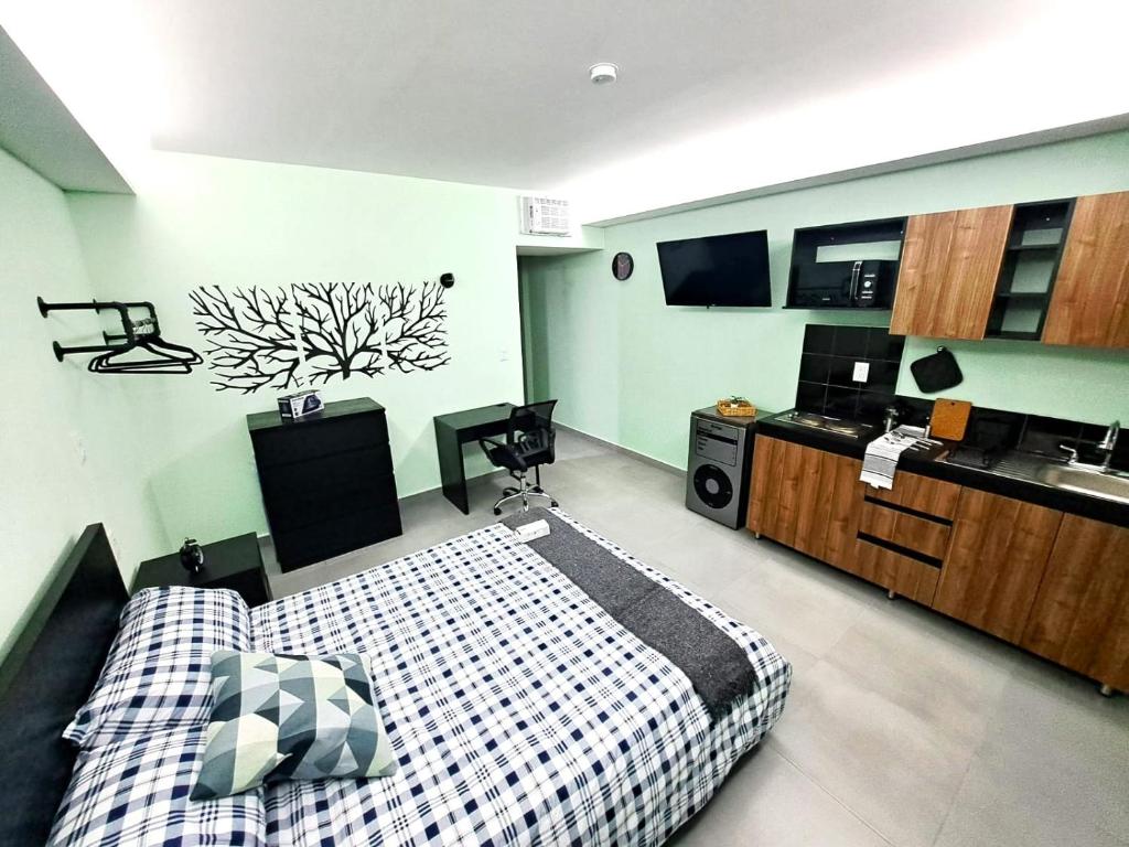 ein Schlafzimmer mit einem Bett und eine Küche mit einer Mikrowelle in der Unterkunft A14 Full Suite ‖ Mini Dept at Plaza Acequia in Municipio Cuautitlán Izcalli