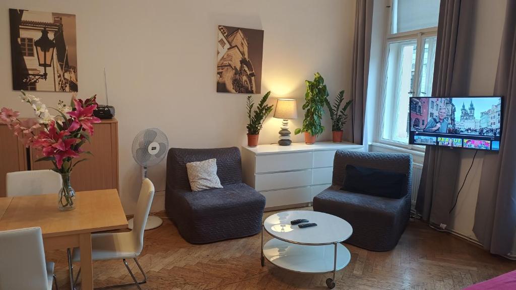 a living room with two chairs and a tv at Apartments in Mala Strana - 10 minutes from Charles Bridge in Prague