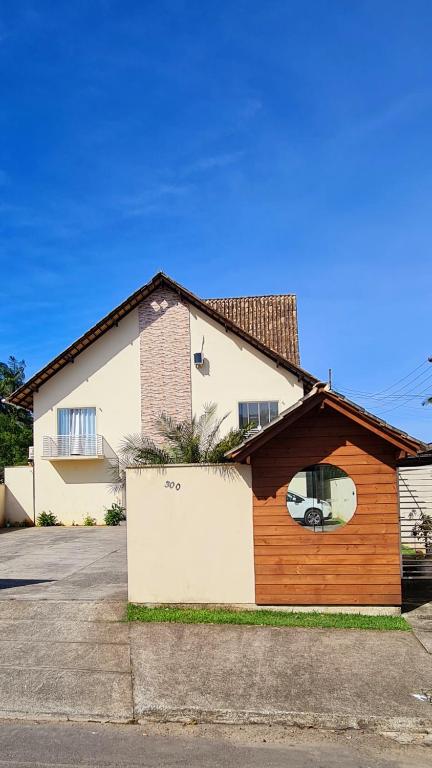 a brown and white house with a garage at Valentina Ramos Pousada - Joinville-SC in Joinville