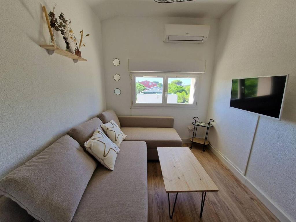 a living room with a couch and a table at Les flamants roses de la Capte T2 in Hyères