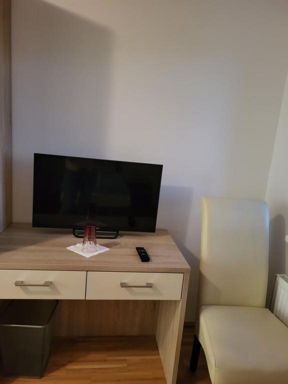 einen Schreibtisch mit einem TV und einem Stuhl in einem Zimmer in der Unterkunft La Gondola in Niederneukirchen