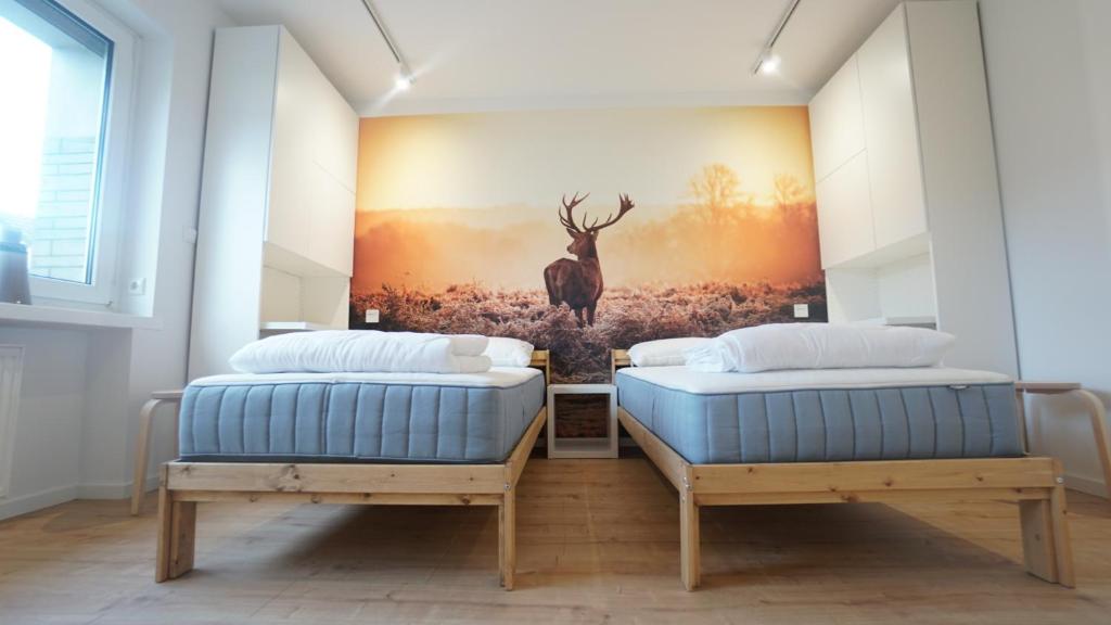 2 camas en una habitación con un cuadro en la pared en ferienwohnung-senne Apartment Romeo, en Schloss Holte-Stukenbrock