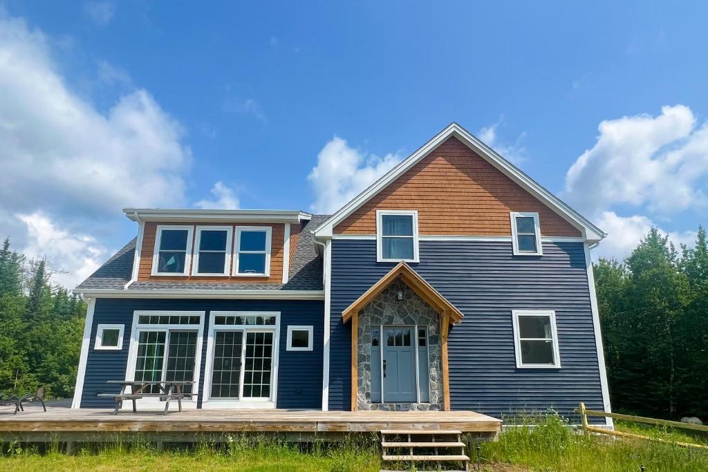 uma casa azul com um alpendre de madeira e uma casa em Ridgeview em Whitefield