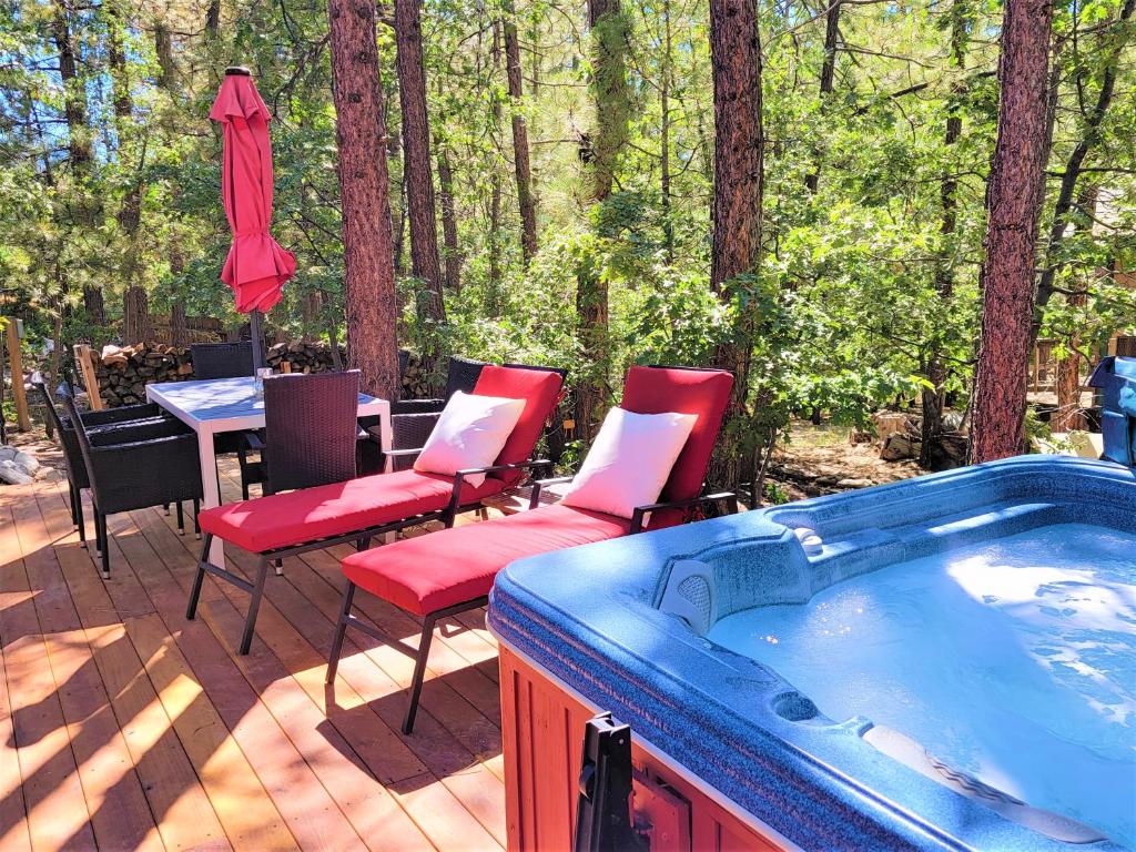 a hot tub on a deck with chairs and a table at Four Seasons Getaway-with Hot Tub, Next to Village and Hiking Trailhead in Big Bear Lake