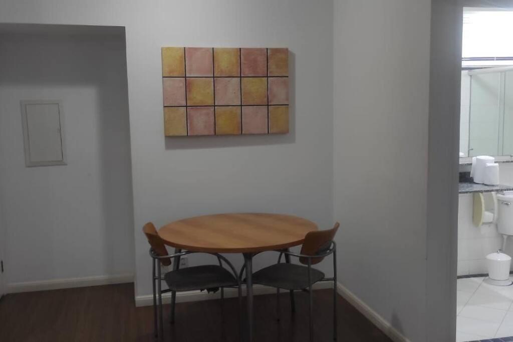 a table and chairs in a room with a painting at Apart Hotel 48 in Mogi das Cruzes