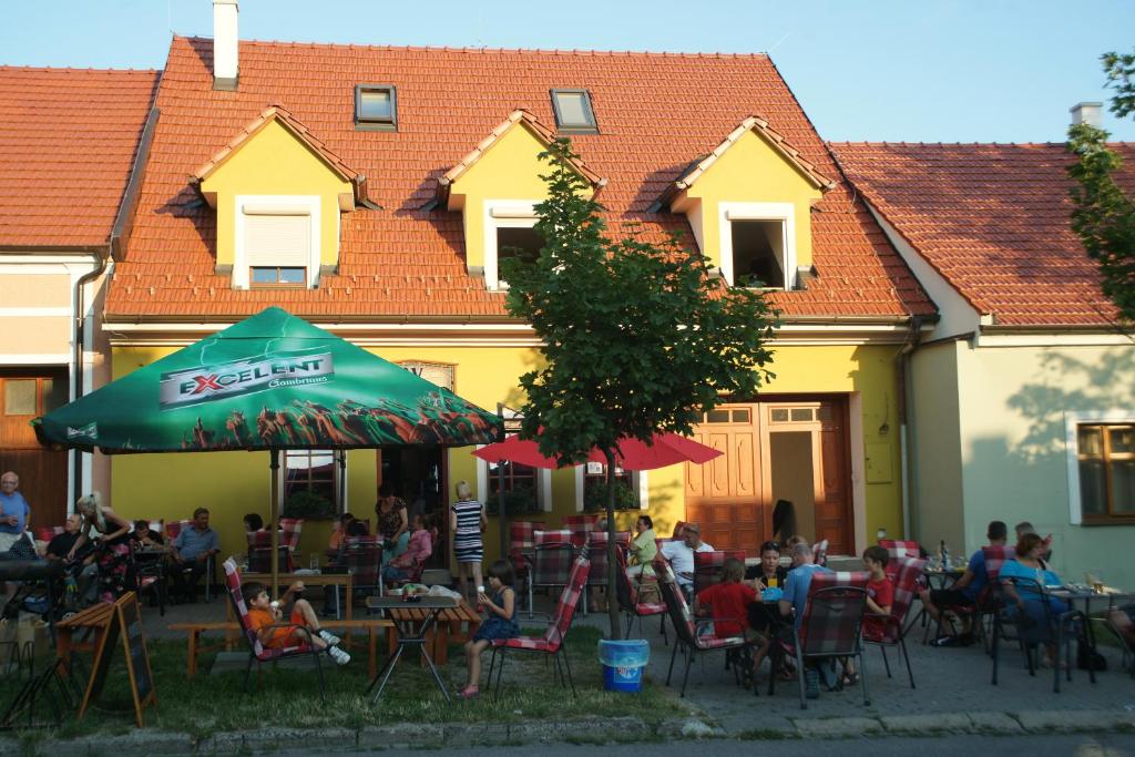 um grupo de pessoas sentadas em mesas em frente a um edifício em Alva Pension 2 em Mikulov