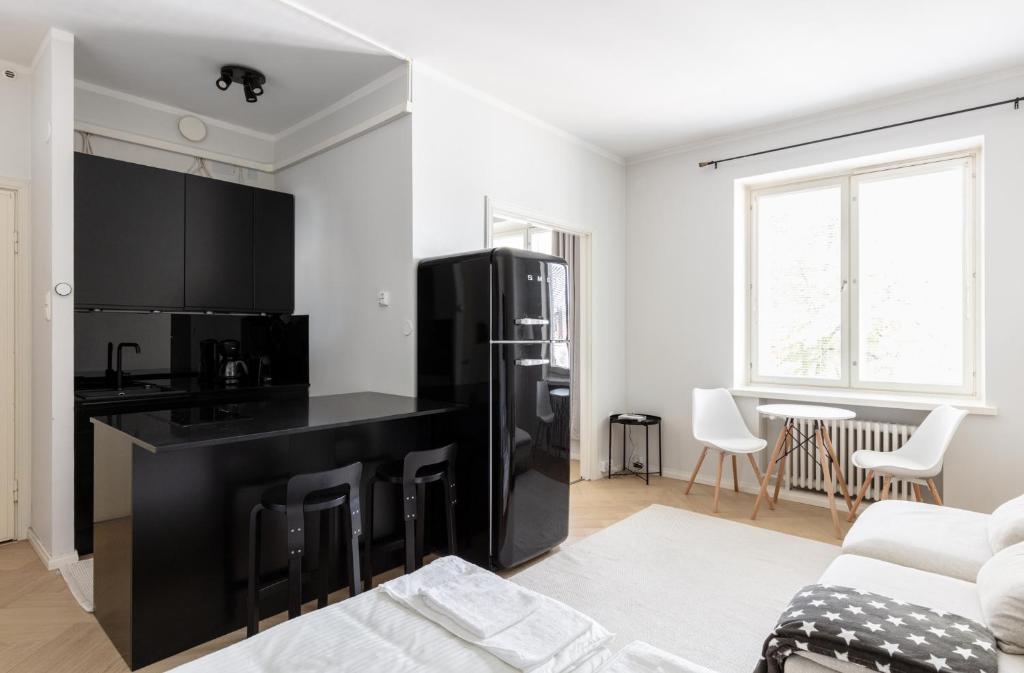 a living room with a black kitchen and a couch at Cozy apartment close to Helsinki Cathedral in Helsinki