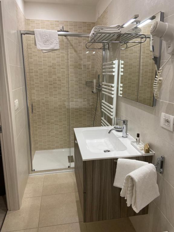 a bathroom with a sink and a shower at International Beach Hotel in Caorle