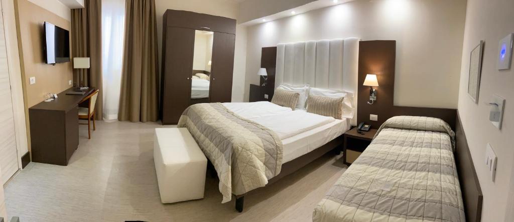 a hotel room with a large bed and a desk at International Beach Hotel in Caorle