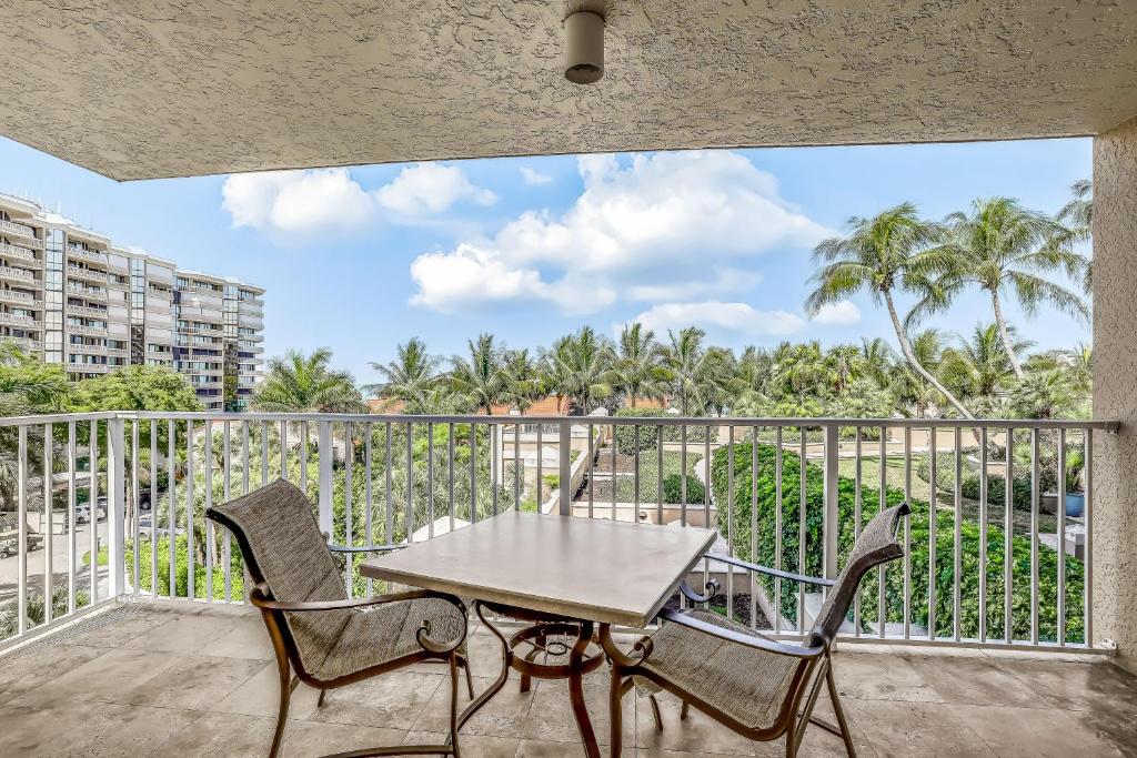 patio con mesa y sillas en el balcón en Marco Beach Ocean Resort 601, en Marco Island