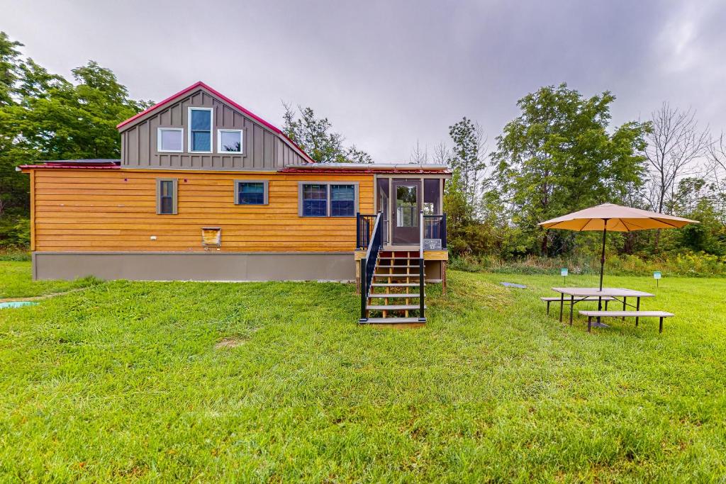 ein winziges Haus mit einer Treppe und einem Regenschirm in der Unterkunft Seneca Lake Serenity in Hector