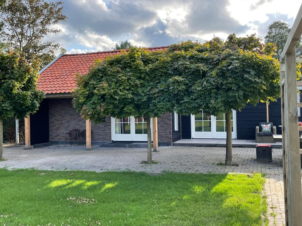 una casa con dos árboles delante de ella en Côté Jardin, en Serooskerke