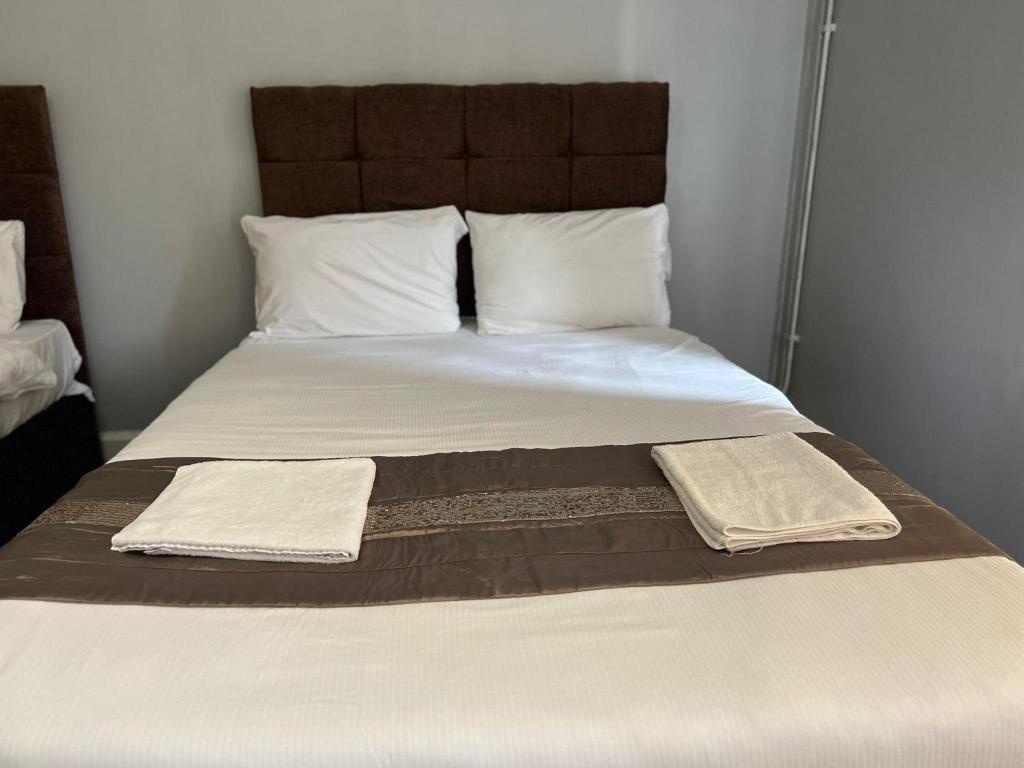 a bed with two pillows and two towels on it at Prime Hotel in Middleton
