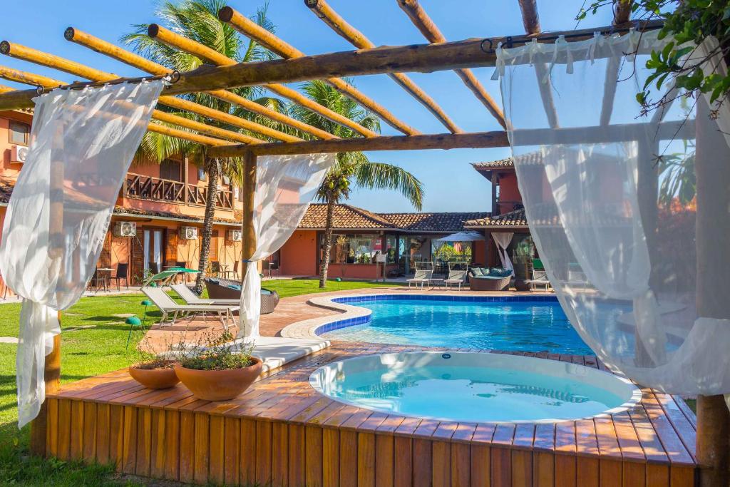 a swimming pool in a backyard with a pergola at Pousada Sabledor in Búzios