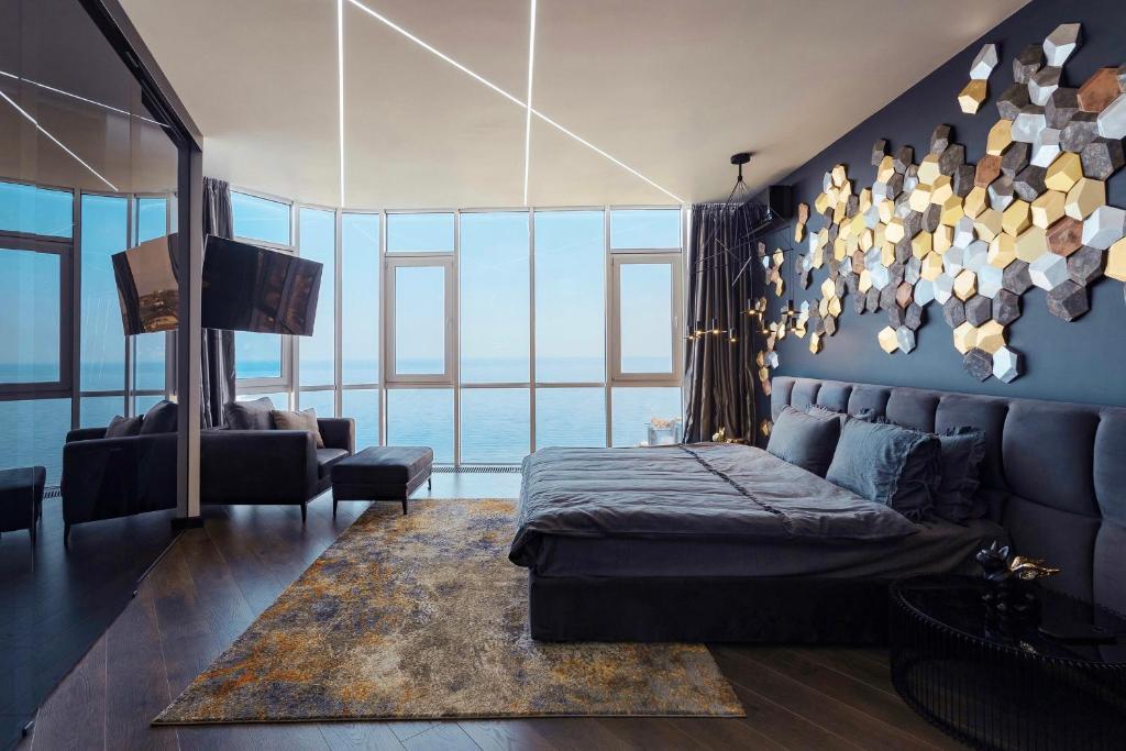 ein Schlafzimmer mit einem Bett und einer blauen Wand in der Unterkunft Odesa Pearl Arcadia in Odessa