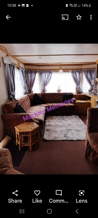 a living room with a couch and a table at Mackies Memories. in Hemsby
